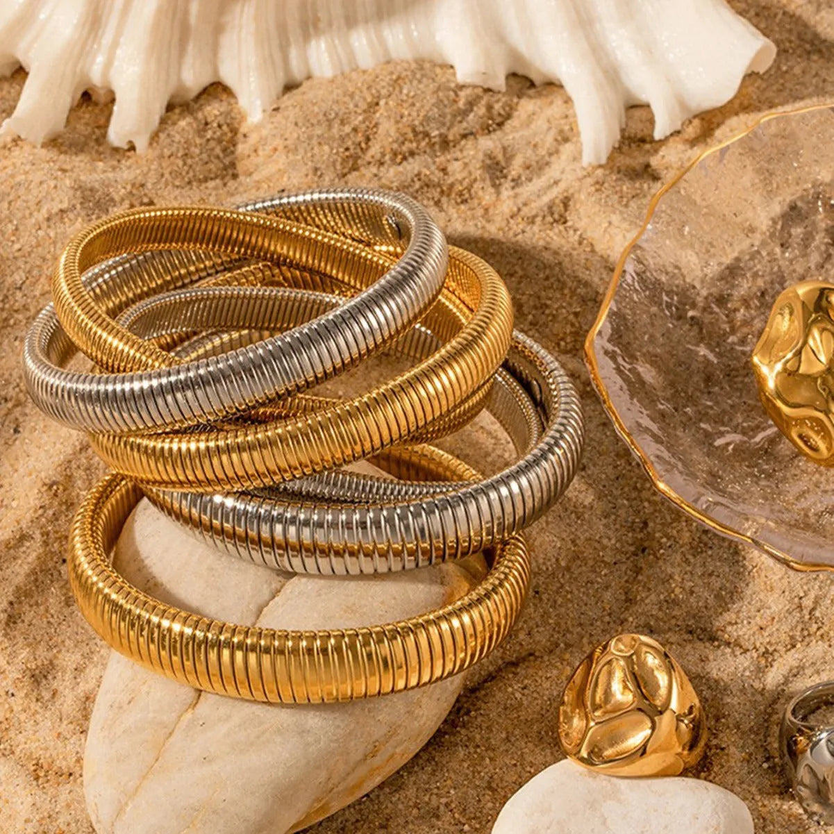 Women's titanium steel elastic bracelet with vertical stripe pattern and ring elements in gold finish