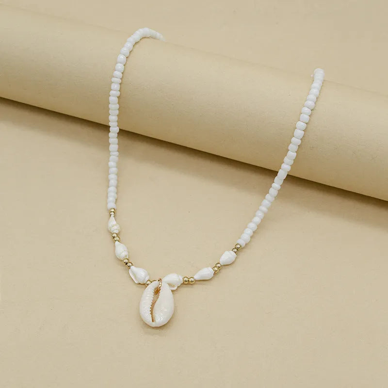 White conch shell necklace with mother pearl pendant on a regular electroplated chain.