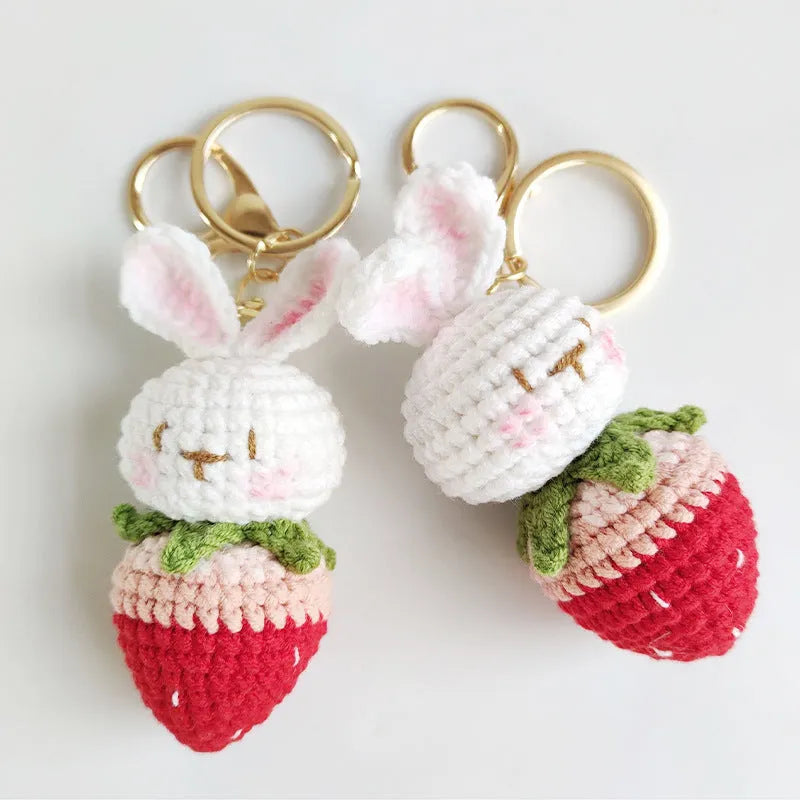 White hand-woven rabbit strawberry wire pendant with key on a white background