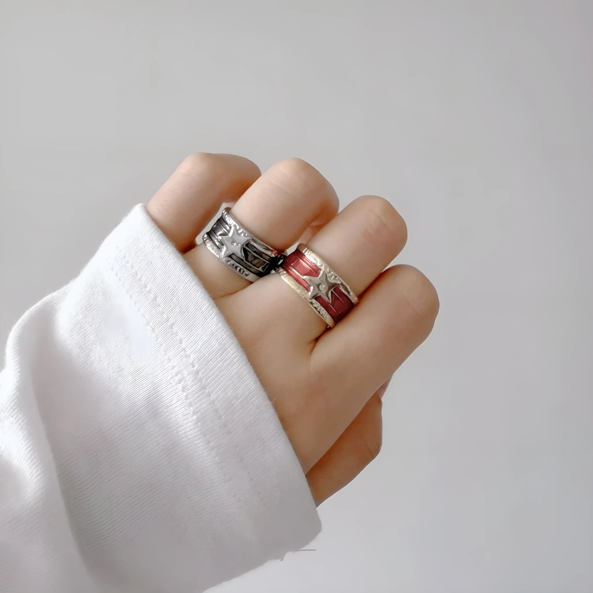 Adjustable copper geometric drop ring with distressed finish in black, red, blue, and black and red.