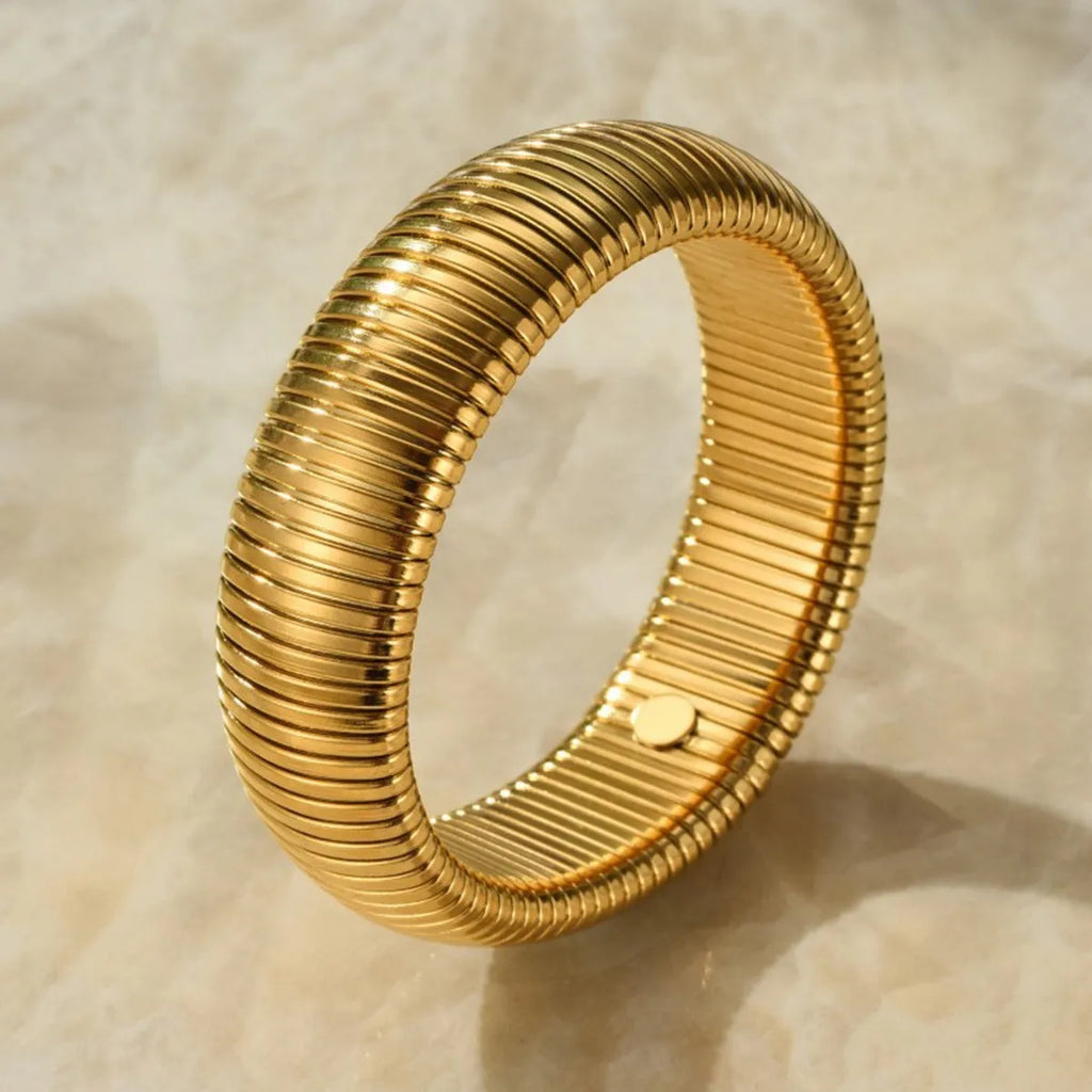 Women's titanium steel elastic bracelet with vertical stripe pattern and ring elements in gold finish