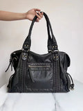 Women's retro motorcycle style messenger bag in bright black with golden edge, showing internal zipper compartments and single shoulder strap