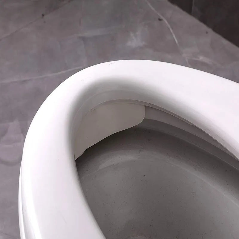 White PVC urine blocking splash guard for toilet training, shown on a toilet seat.