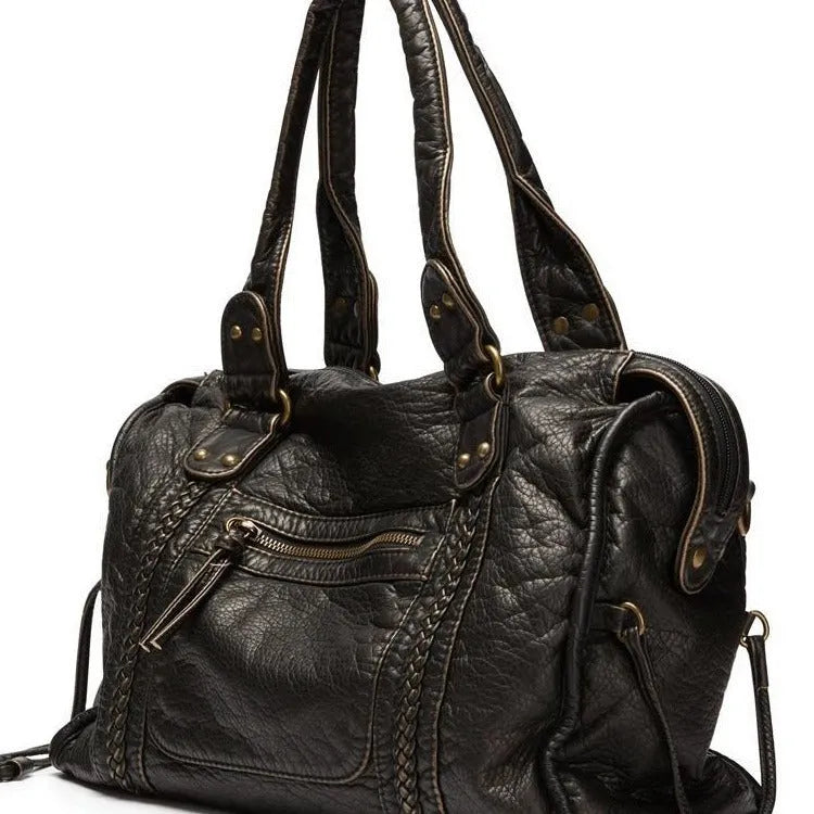 Women's retro motorcycle style messenger bag in bright black with golden edge, showing internal zipper compartments and single shoulder strap