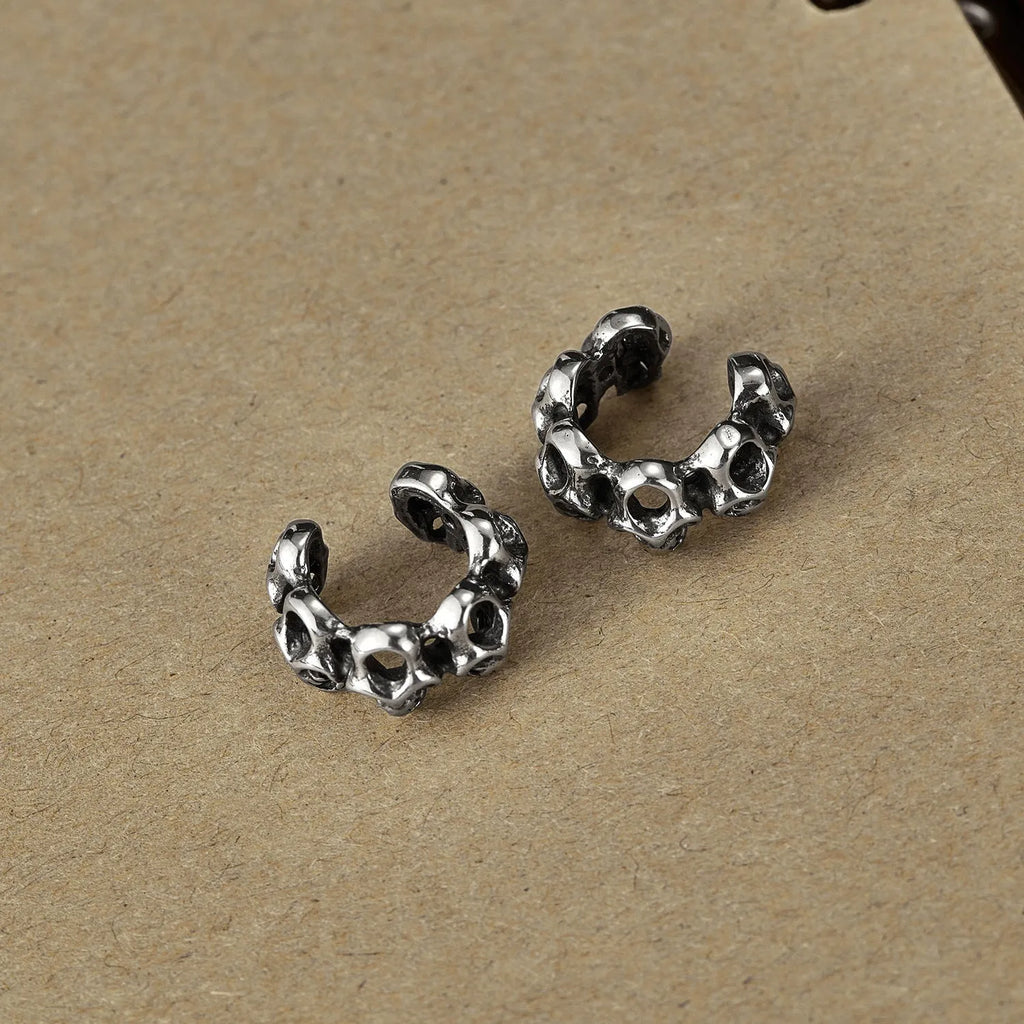 Stainless steel skull ear clips with hollow geometric design and electroplated metallic finish