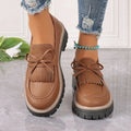 Women's plus size black loafers with tassel detail and a chunky flat rubber sole.