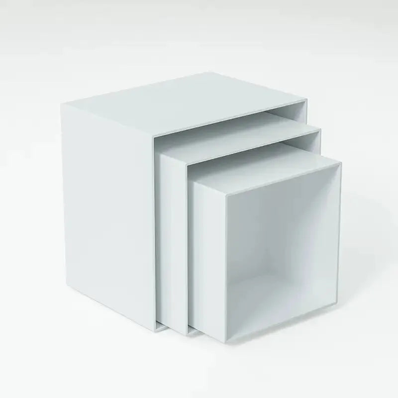 Six white plastic cube dessert display stands arranged on a table.