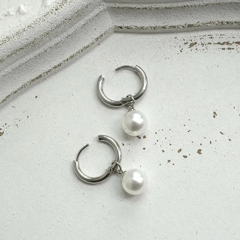 A pair of women's geometric alloy earrings with round pearl details and titanium steel posts.