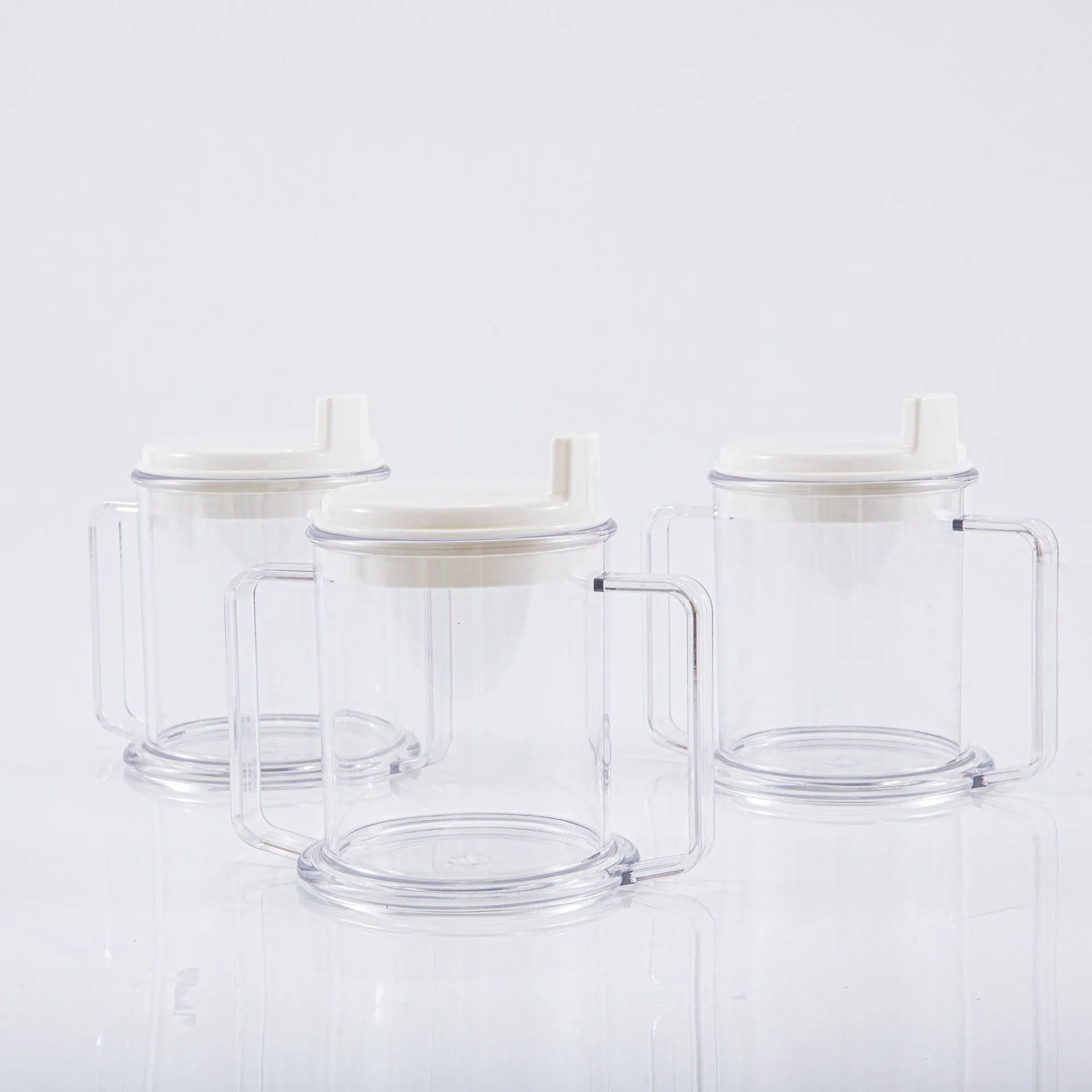 Transparent plastic drinking cup with a black spill-proof lid on a white background