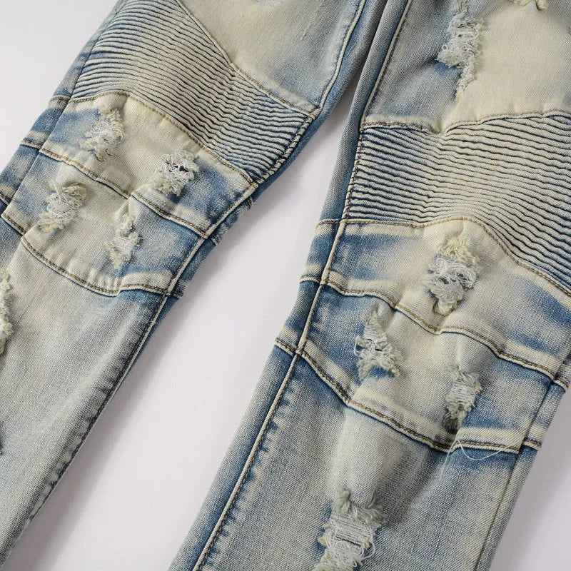 Men's light blue slim fit distressed stretch jeans with hand-frayed detailing on a mid waist with zipper fly.