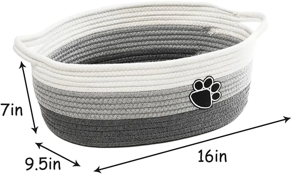 Light beige handmade cotton rope storage basket with handle on a wooden surface.