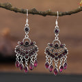 Long purple fringe drop earrings with retro crystal design on a white background.