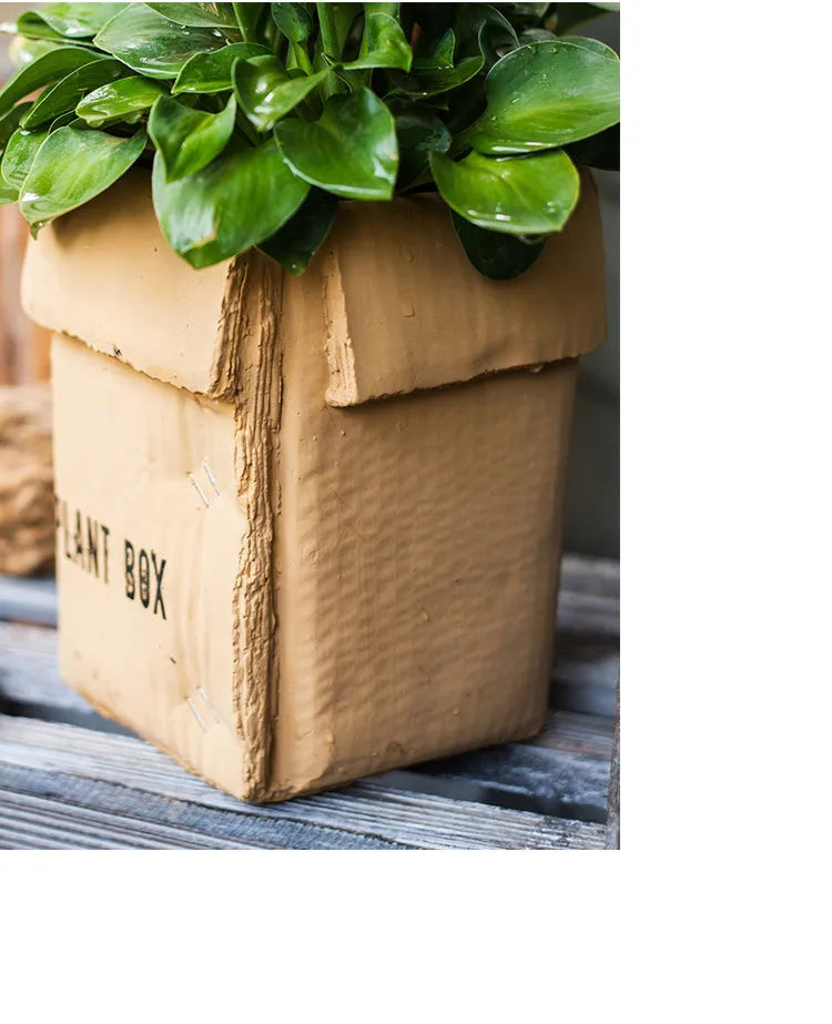 Cement flowerpot with brown paper box texture and bottom drainage holes on a floor.