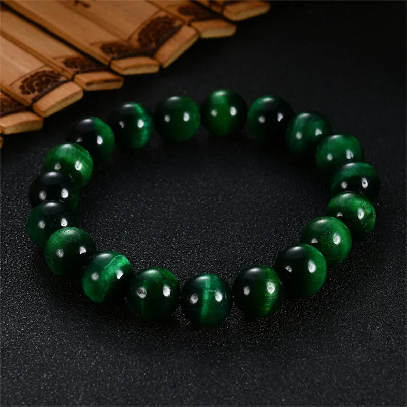 Green Tiger Eye stone geometric bead bracelet on wrist, showing polished surface and banding.