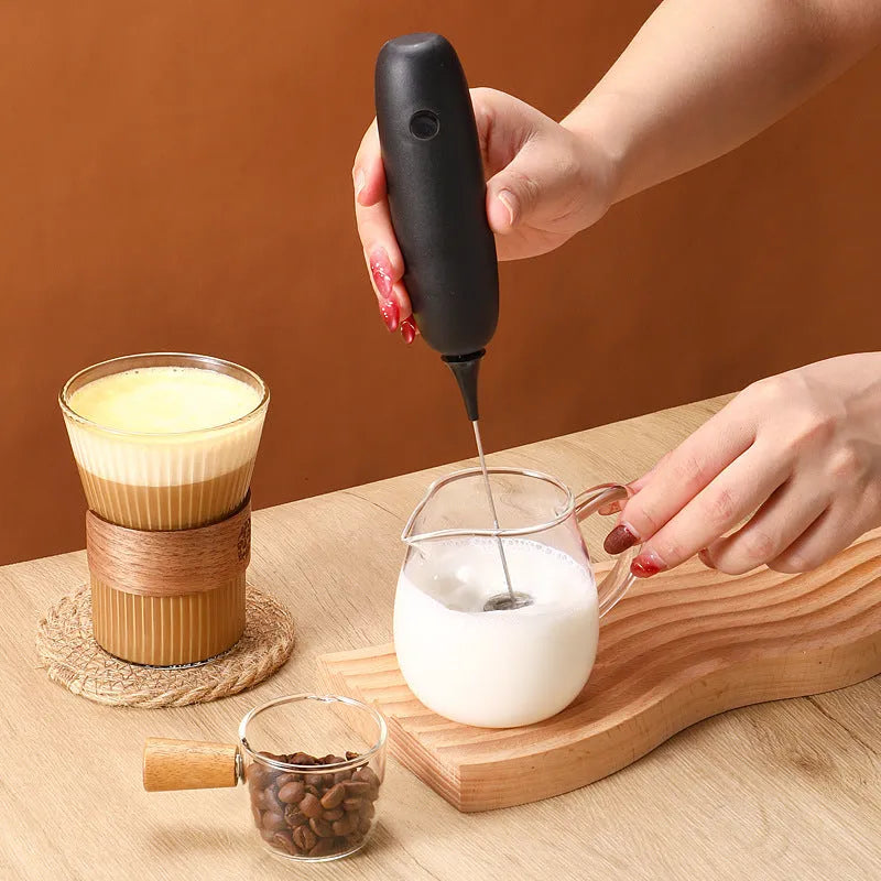 Black and white hand-held electric milk frother blender for coffee