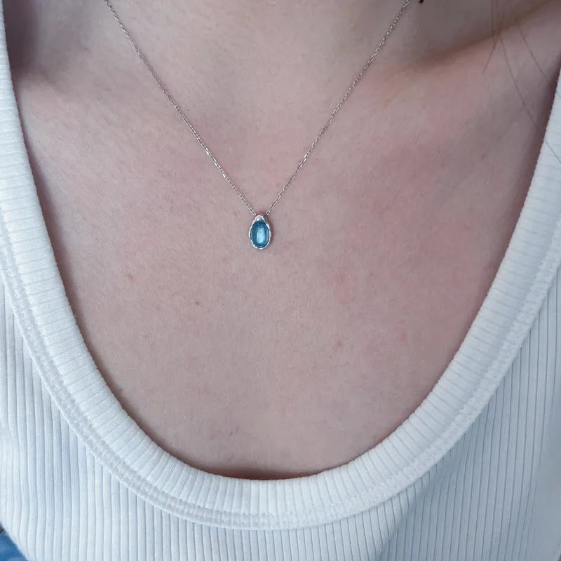 Navy blue water drop necklace with geometric design on adjustable cross chain