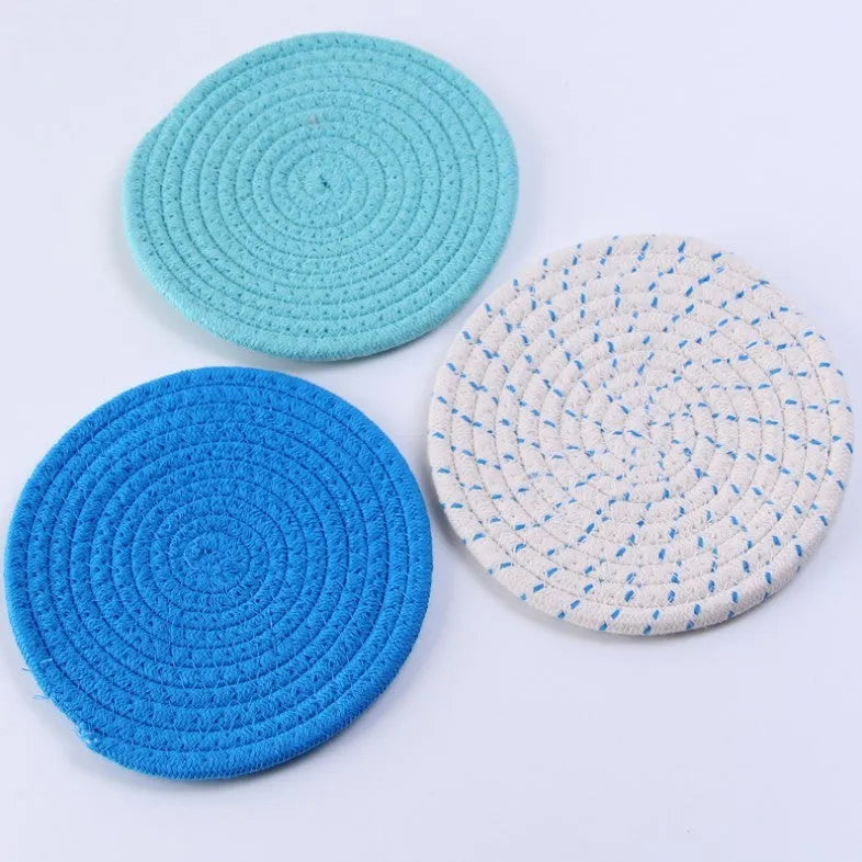 Set of three round cotton cord coasters in a choice of colours on a wooden table