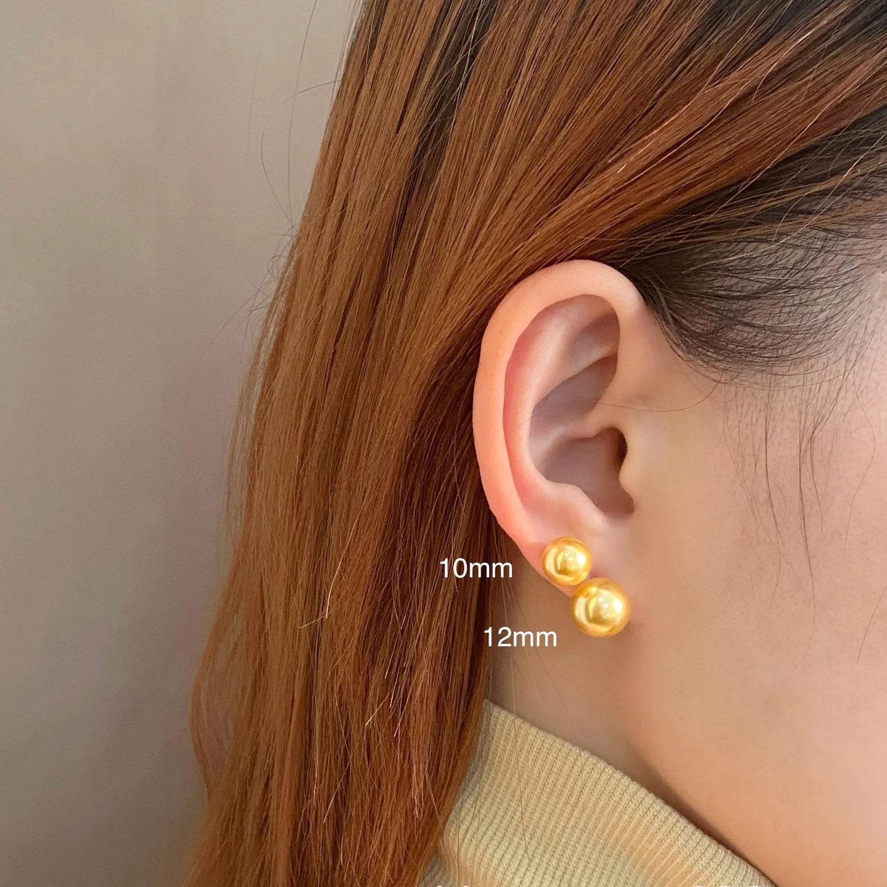 A pair of large pearl stud earrings with a geometric silver setting on a white background.