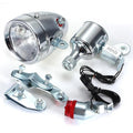 Silver bicycle dynamo generator light kit mounted on a bike fork, with wires for headlight and tail light connections.
