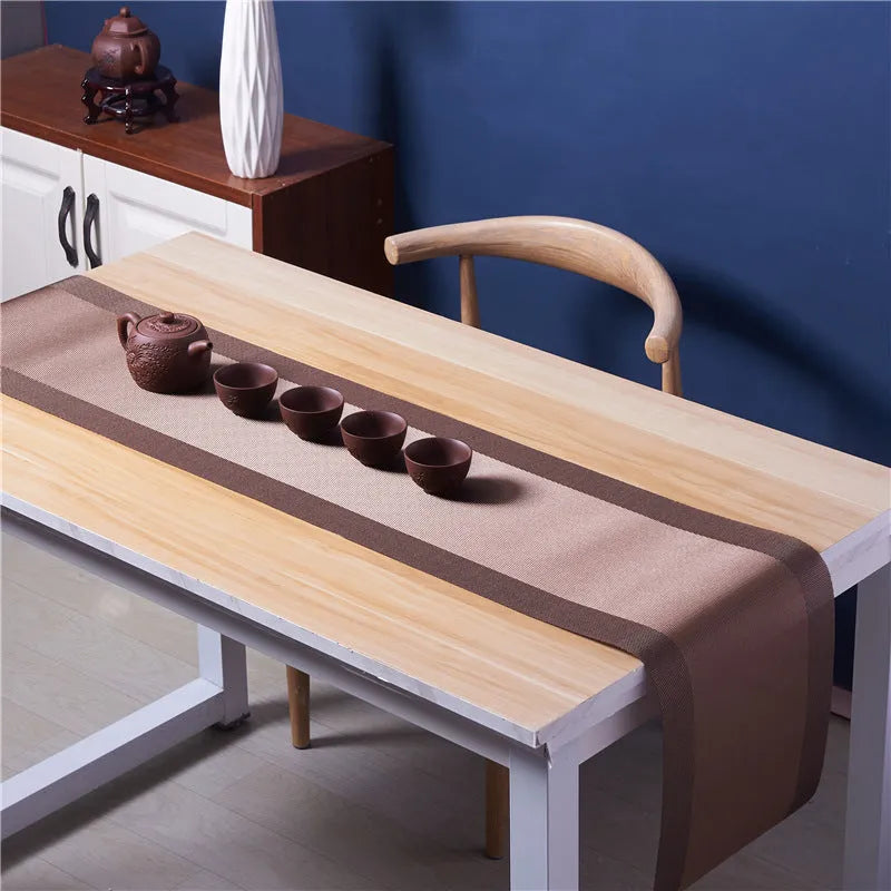 Modern non-slip PVC dish mat with gradient bamboo pattern in black, placed on a wooden dining table.