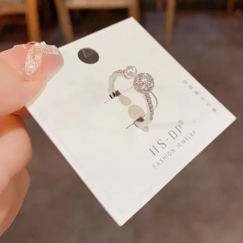 Women's open-end ring with round zircon and pearl detail in gold or silver finish