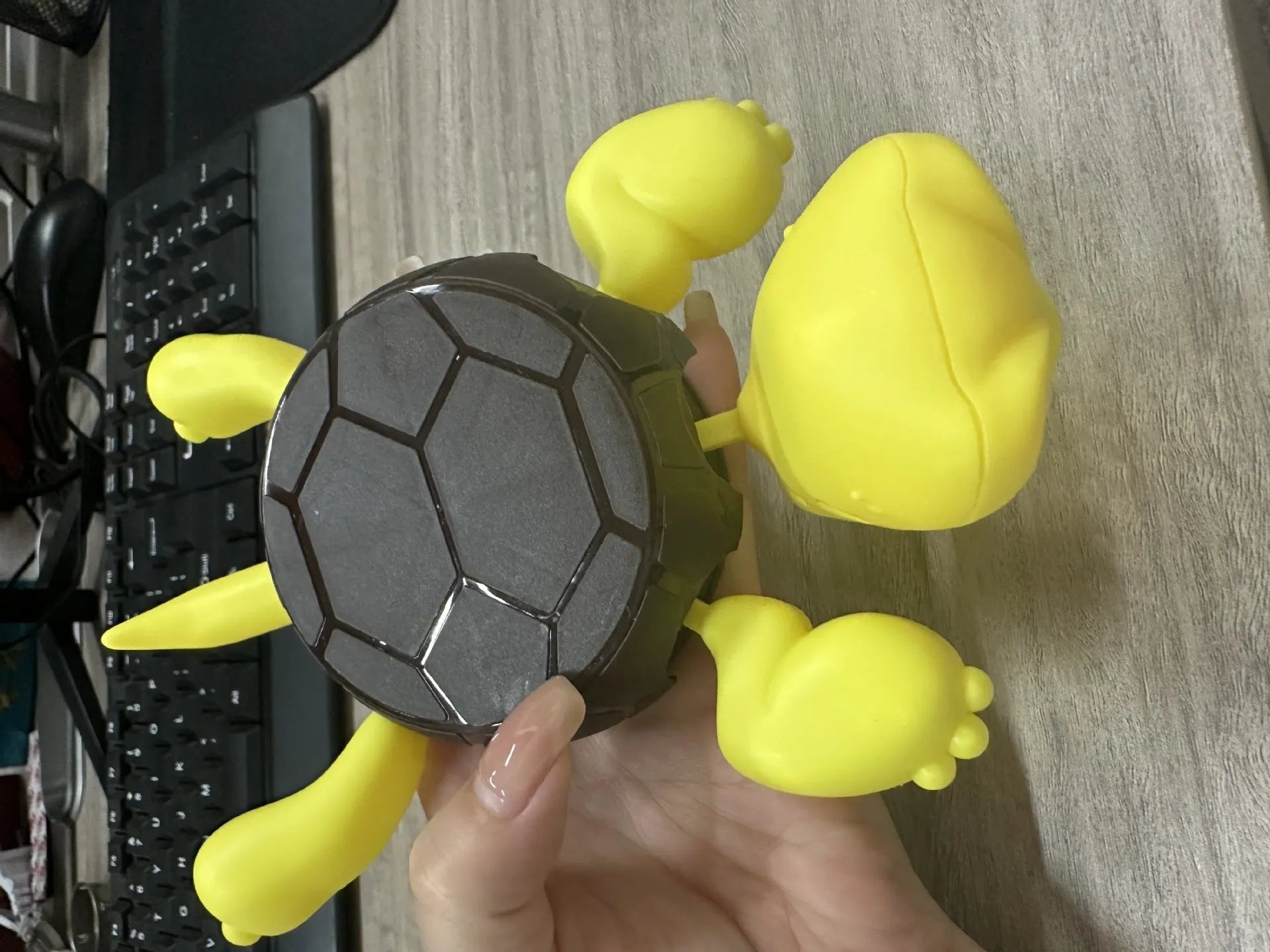 Turtle shaped plastic coaster in green, yellow, and wheat starch colours for heat insulation.