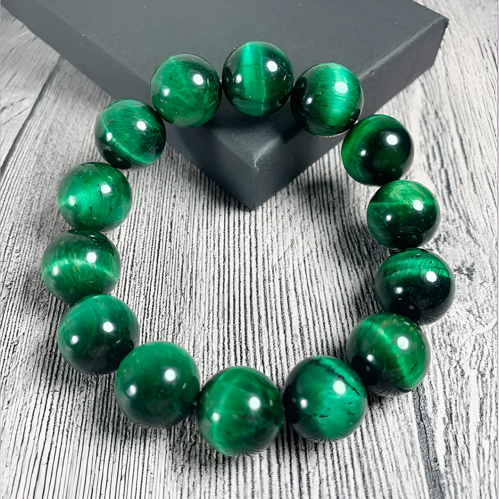 Green Tiger Eye stone geometric bead bracelet on wrist, showing polished surface and banding.