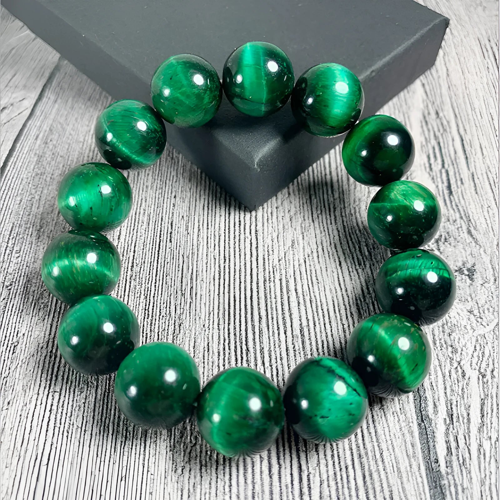 Green Tiger Eye stone geometric bead bracelet on wrist, showing polished surface and banding.