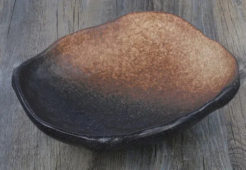 Creative Japanese ceramic sashimi bowl with irregular shape and floral decoration on table