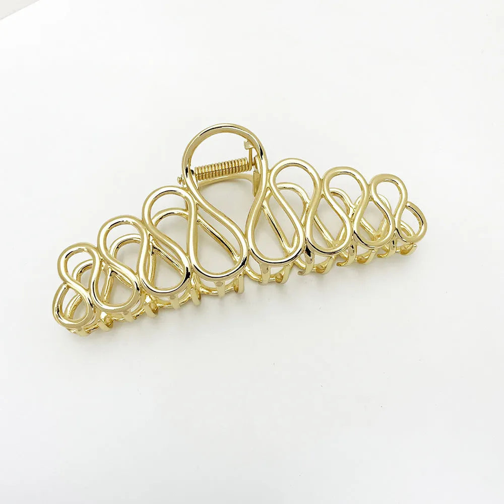 Minimalist large hair clip with tassel detailing in gold or silver metallic finish for updo hairstyles