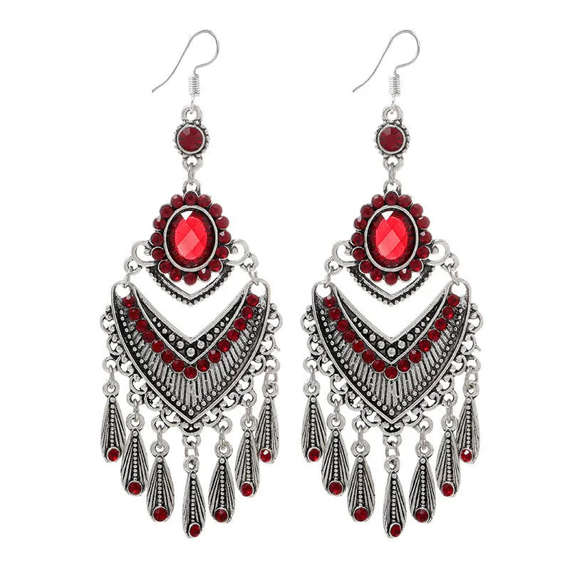 Long purple fringe drop earrings with retro crystal design on a white background.
