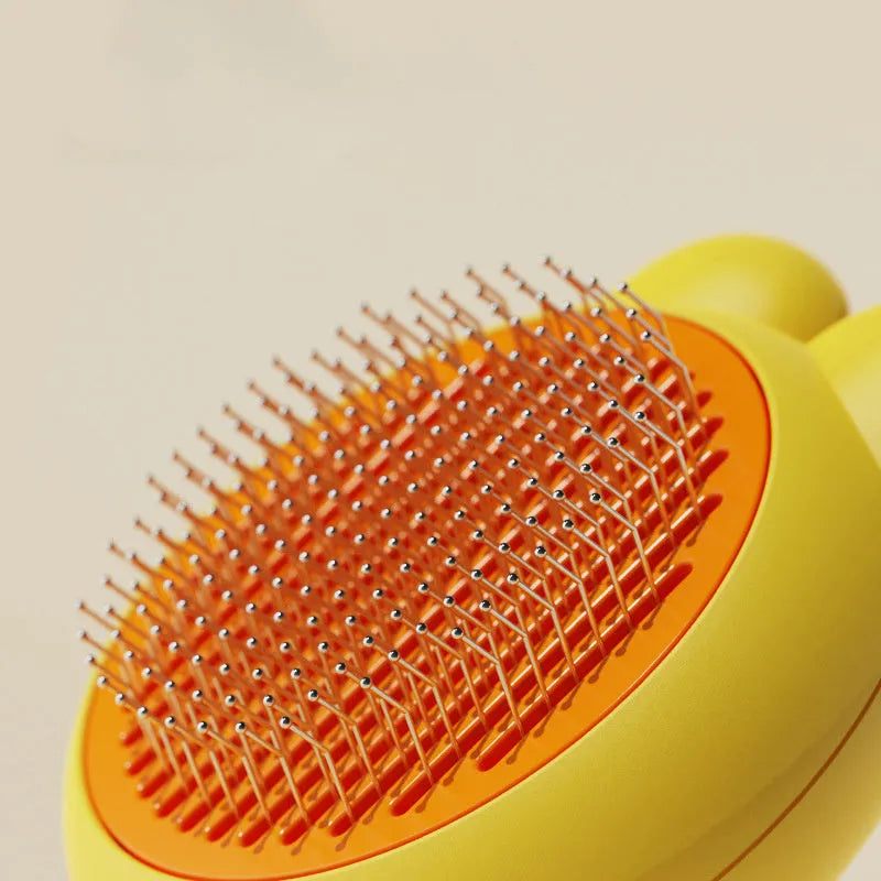 Green pet grooming brush with a self-cleaning button and a stainless steel comb.