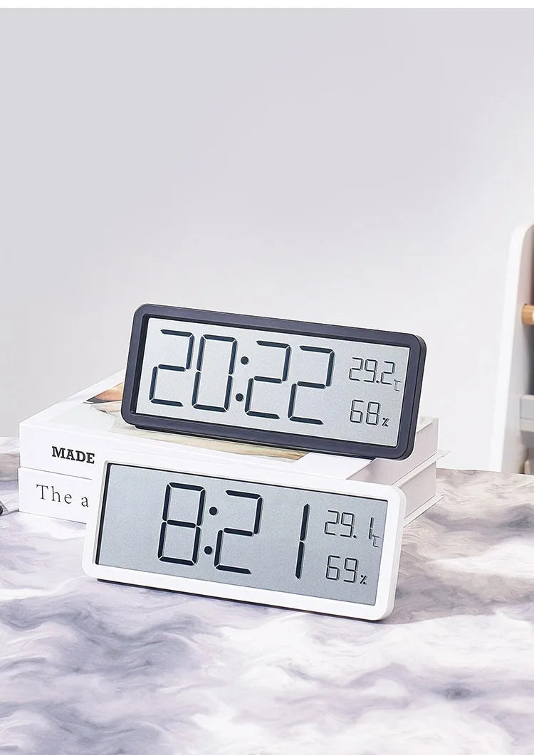 Simple large screen temperature and humidity clock in plastic with Nordic style, black colour, on a desk.