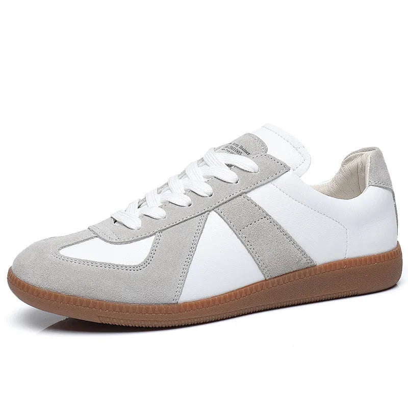 Men's low top white retro sneakers with round toe and flat rubber sole on a plain background