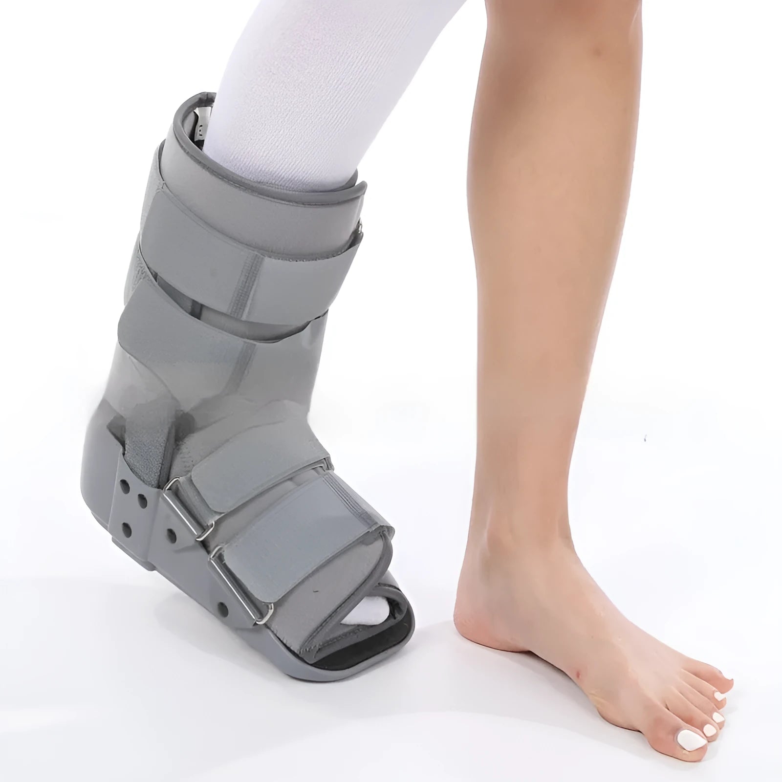 Grey achilles tendon rehabilitation boot with adjustable straps and a rigid plastic shell on a rubber sole.