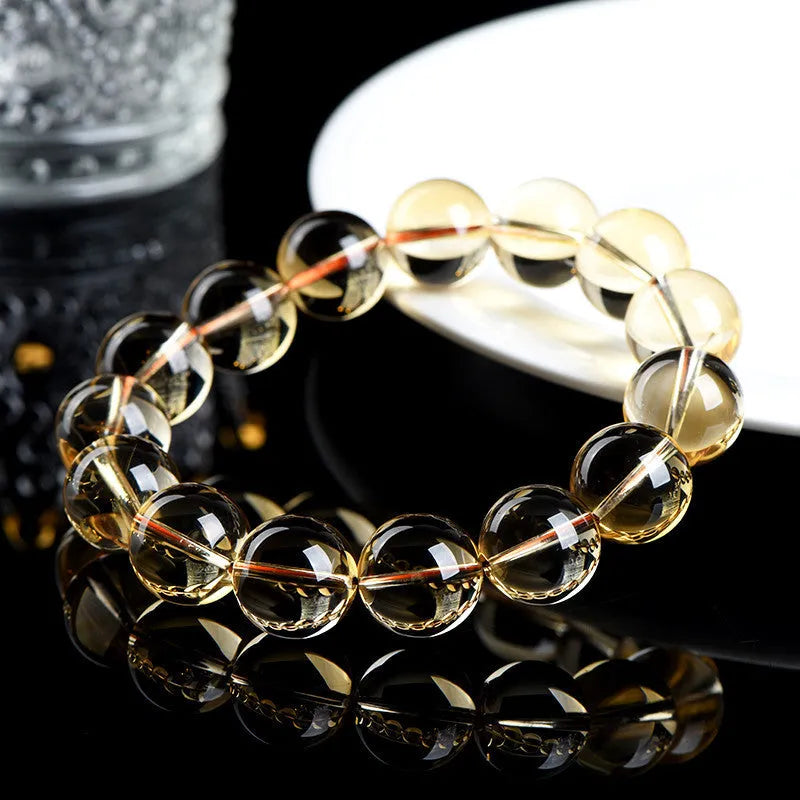 Natural citrine scattered beads ball bracelet showing polished yellow stone beads on wrist.
