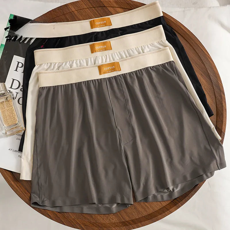 Pack of men's solid colour ice silk boxer shorts showing loose fit and mid-waist design.