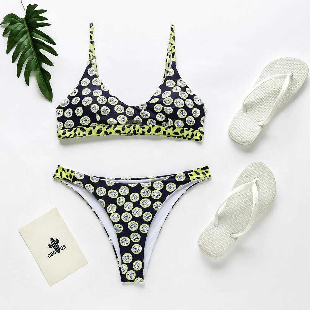 Women's black and white polka dot polyester bikini swimsuit laid flat, showing top and bottom pieces.