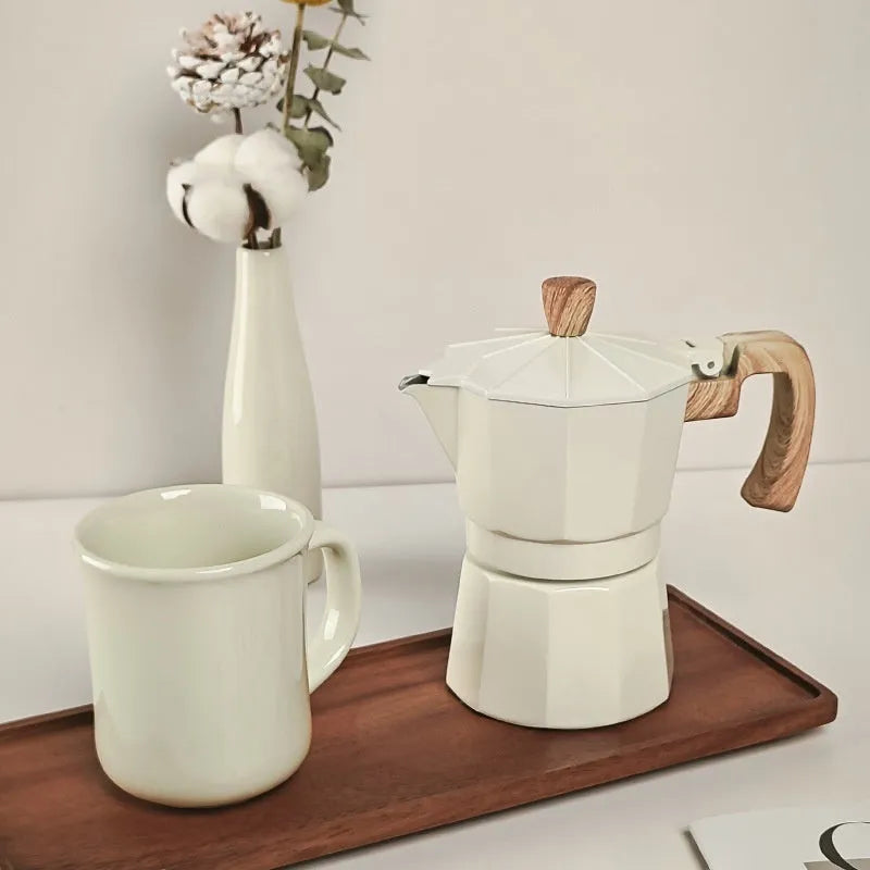 Six-piece manual grinding machine set in beige and black with moka pot, cup, bean jar, and accessories