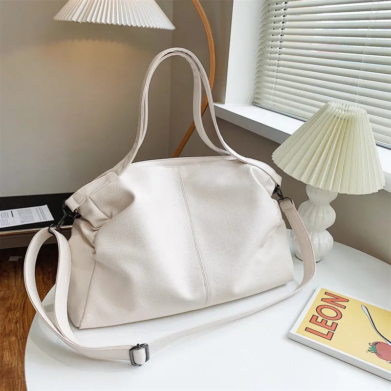 Large horizontal square soft-surface PU leather messenger bag with a long shoulder strap and zip opening.