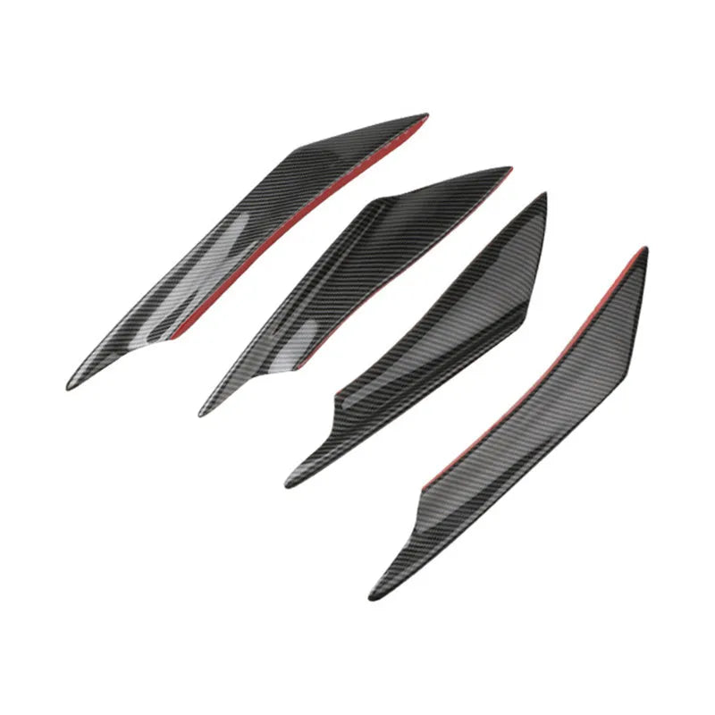 Set of four carbon fibre pattern bumper blade spoilers for car modification on a black background.
