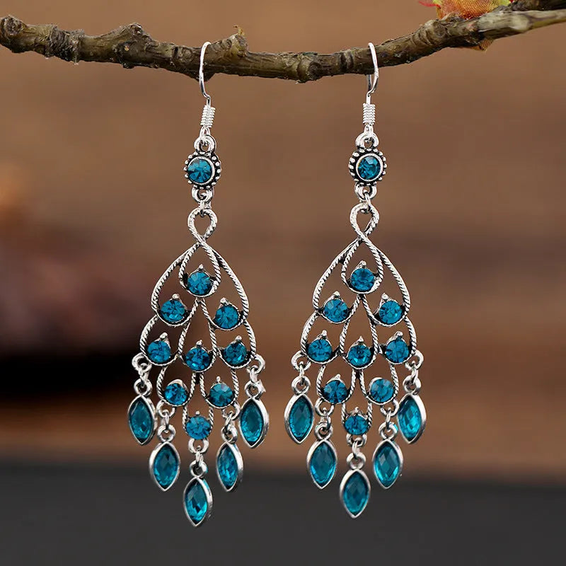 Long purple fringe drop earrings with retro crystal design on a white background.