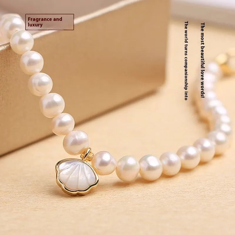 Close-up of a women's freshwater pearl bracelet with pearls arranged in a fan shape on a wrist.