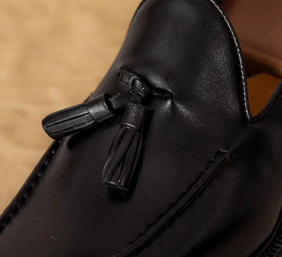 Men's black leather slip-on loafers with fringed detailing and polished finish