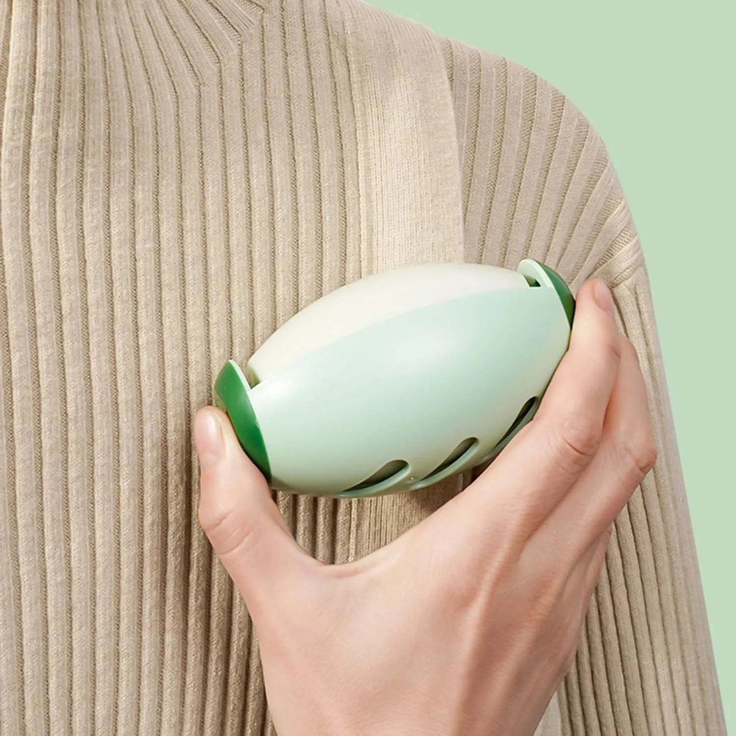 Green washable gel lint roller ball removing pet hair from blue fabric