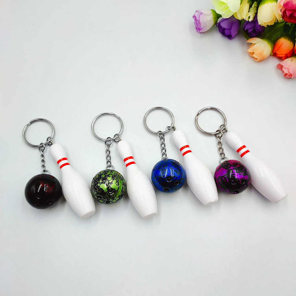 Mini bowling ball keychain pendant in PVC metal showing four colour options: dark red, blue, purple, green