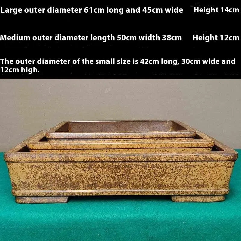 Straight shallow rectangular Yixing Zisha flowerpot in purple sand clay on a plain surface.