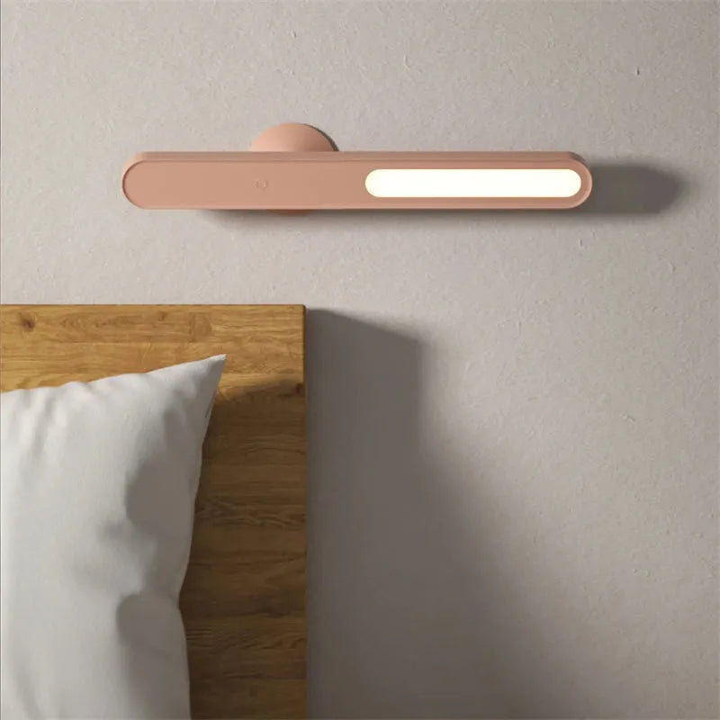 White geometric desk lamp with touch control and magnetic base on a wooden table.
