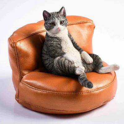 Small resin cat ornament sitting on fabric sofa for car dashboard decoration