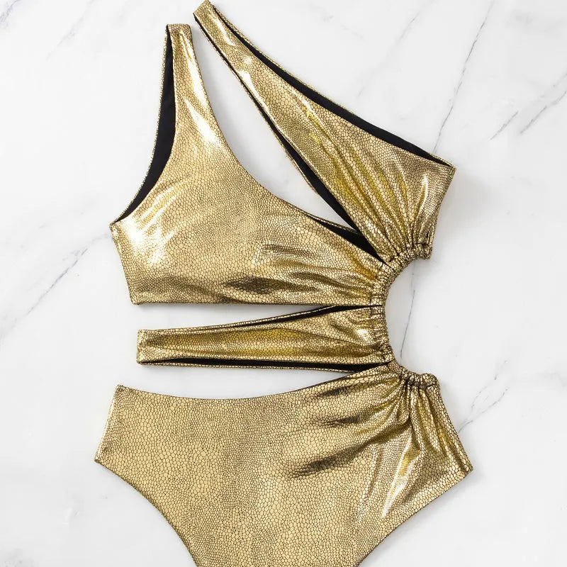 Gold women's backless one-piece swimsuit on a neutral background, showing sleeveless design.